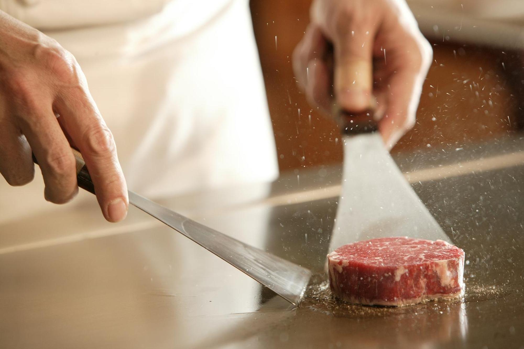 미야코 호텔 기후 나가라가와 외부 사진 A chef seasoning a steak